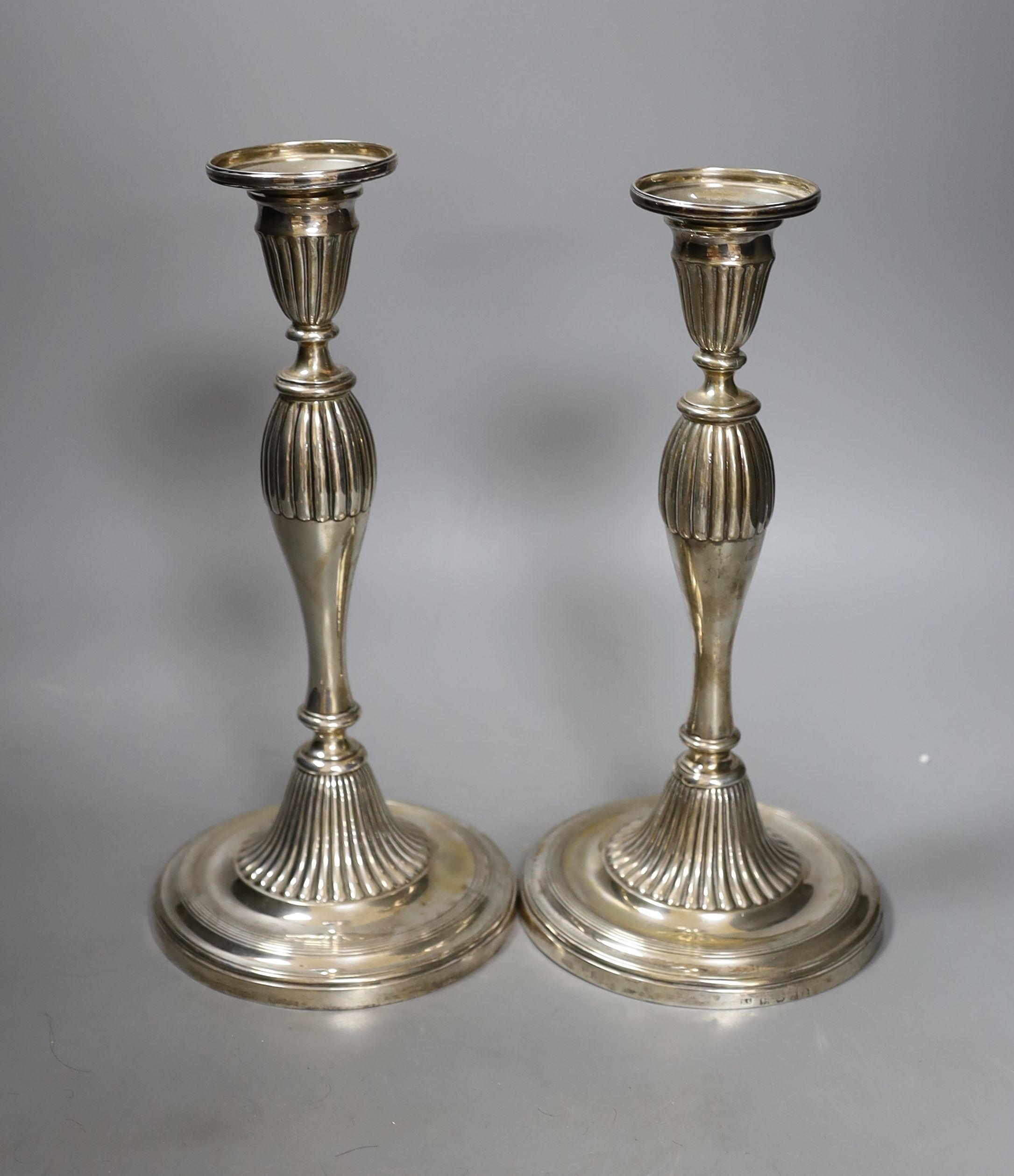 A pair of George III silver candlesticks, with waisted fluted stems, R.S. Sheffield, 1793 & 1796, 22.9cm, weighted (a.f.).